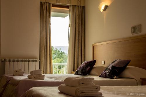a hotel room with two beds with towels on them at Hotel Pinheiro Manso in Seara