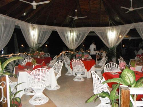 a group of white chairs and tables in a marquee at Rondel Village in Negril