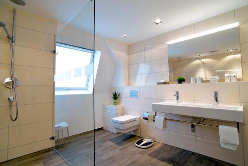 uma casa de banho com um lavatório e um chuveiro em Hotel Lindenhof em Emsdetten