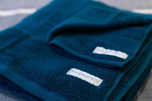 two blue towels sitting on top of a table at Flinders Lane Superior Studio Apartment in Melbourne