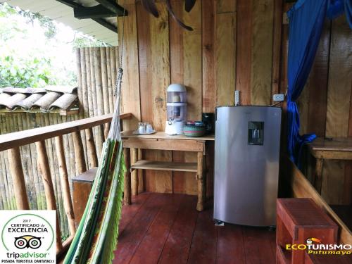 a kitchen with a refrigerator in a cabin at Posada Turistica Dantayaco in Mocoa