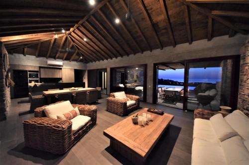 ein Wohnzimmer mit Sofas und einem Tisch sowie eine Küche in der Unterkunft Villa Molivos Views in Mythimna