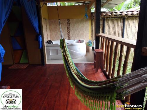 a hammock on a porch with a bath tub at Posada Turistica Dantayaco in Mocoa