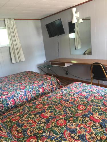 a hotel room with a bed with a colorful blanket at Melody Motor Lodge in Connellsville
