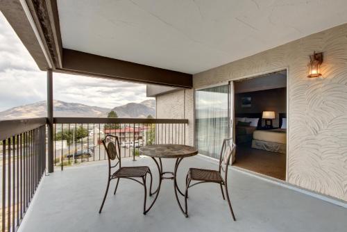 a room with a balcony with a table and chairs at Knights Inn Kamloops in Kamloops