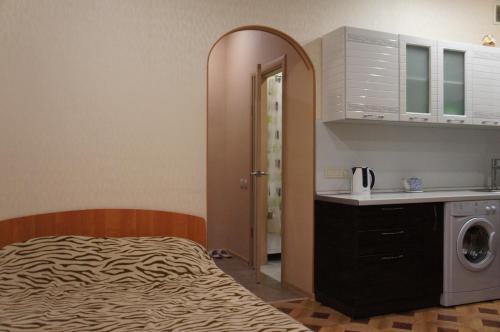 イルクーツクにあるАпартаменты на Юрия Тенаの小さなベッドルーム(ベッド1台付)、キッチンが備わります。