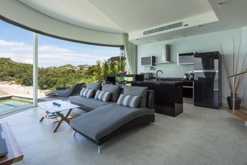a living room with a couch and a kitchen at Villa Callisto in Thong Son Beach