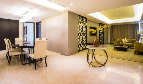a dining room and living room with a table and chairs at Solymar Hotel & Beach in Manama