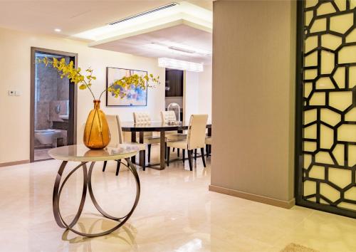 a dining room with a table with a vase on it at Solymar Hotel & Beach in Manama