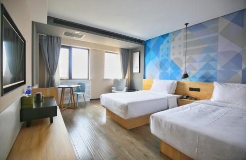 ein Hotelzimmer mit 2 Betten und einem Tisch in der Unterkunft Atourlight Hotel Xi'an University City Store in Xi'an