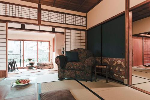 een woonkamer met een stoel en een tafel bij Guest House Yonemuraya in Matsue