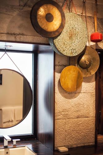 a mirror and different types of hats hanging on a wall at The Bivou Lijiang in Lijiang