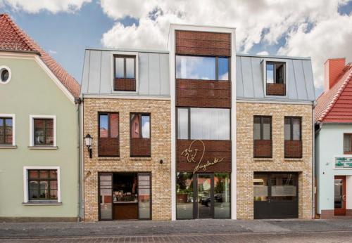 a tall brick building with windows on a street at Ringelnatz Inselhotel in Malchow