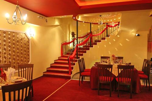 a restaurant with a staircase and a table and chairs at Charlino Plaza in Ruse