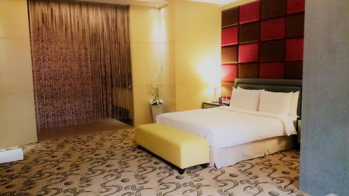 a bedroom with a white bed and a yellow stool at Her Home Spa Motel Xinying in Xinying