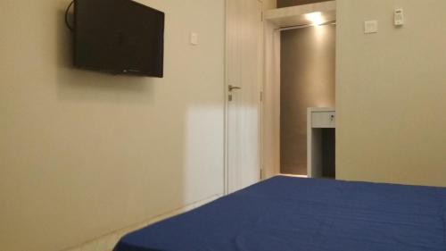 Schlafzimmer mit einem blauen Bett und einem Flachbild-TV in der Unterkunft SleepRest - Plamo Garden in Batam Center