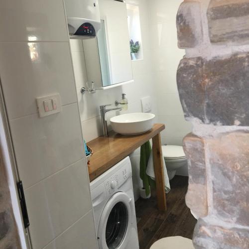 a bathroom with a sink and a washing machine at Dream house in Zaglav