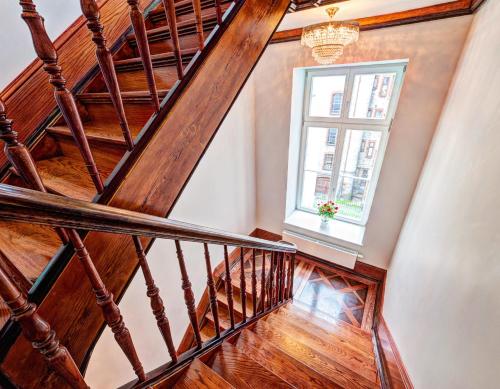a wooden staircase with a window and a chandelier at Fortune Old Town boutique hotel in Poznań