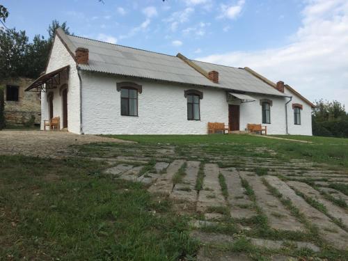 a white house with a grass yard in front of it at Hotel Rafinad in Sharhorod