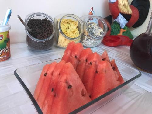 une assiette de pastèque sur une table avec d'autres aliments dans l'établissement Family Hotel Avenue , à Kiten