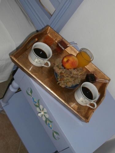a tray with two cups of coffee and a bowl of fruit at Pansion Limni in Keri