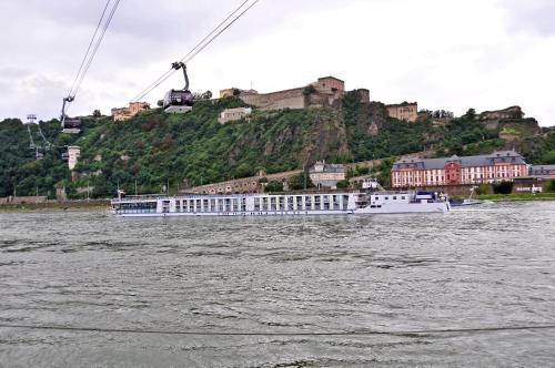 a large white boat on the water with a hill at Haus Rheinterrasse in Koblenz