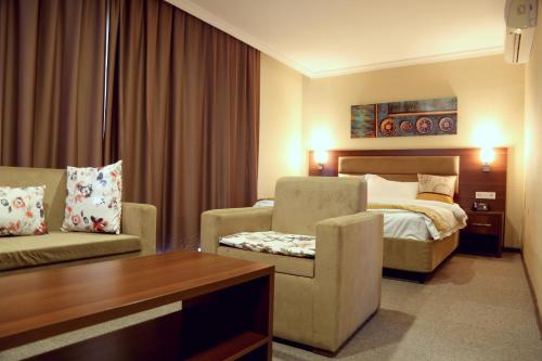 a hotel room with a bed and a couch at Hotel Halwachy in As Sulaymānīyah