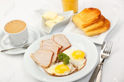 a plate of breakfast food with eggs and bread and a cup of coffee at Anurak Guesthouse in Bangkok