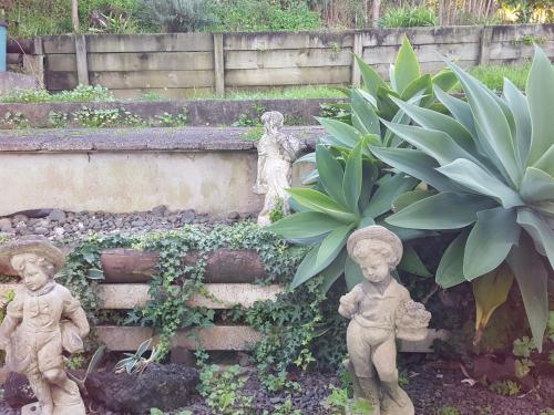 a garden with two statues next to some plants at Harbour View Guesthouse in Auckland