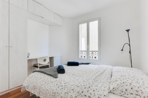 パリにあるCosy Appartment Arc de Triomphe Champs Elyseesの白いベッドルーム(ベッド1台、窓付)