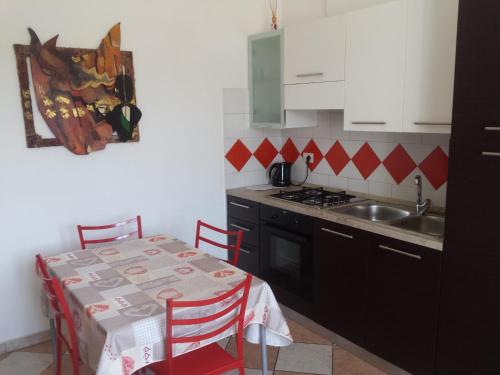 a small kitchen with a table and a sink at Residence Shopping Outlet in Novi Ligure