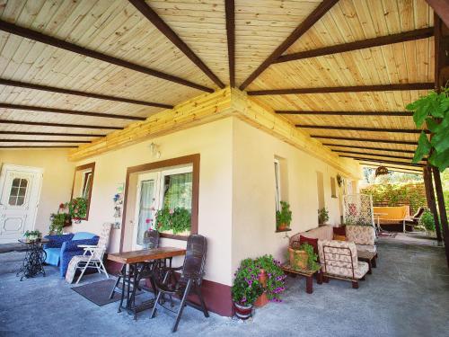 a patio with a wooden ceiling with chairs and a table at Pokoje Gościnne Gazda in Polanica-Zdrój
