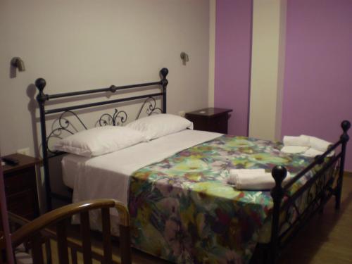 a bedroom with a bed with a floral bedspread at Agriturismo Casale Sera in Fontana Liri