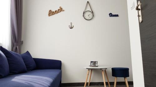 a living room with a blue couch and a table at Hotel Roztocze in Zwierzyniec