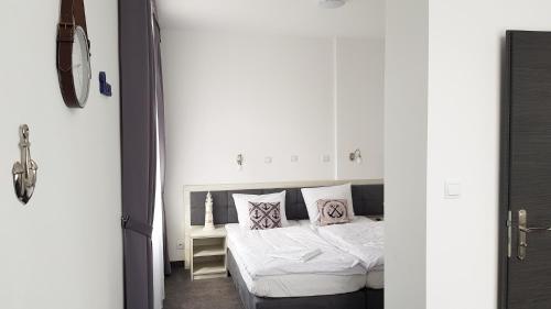 a bedroom with a bed with white sheets and pillows at Hotel Roztocze in Zwierzyniec