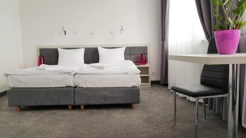 a bedroom with a bed and a chair at Hotel Roztocze in Zwierzyniec
