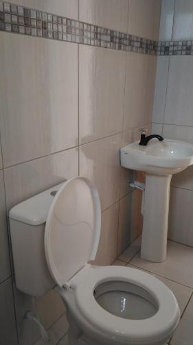 a bathroom with a toilet and a sink at Sereia de Carapibus in Jacumã