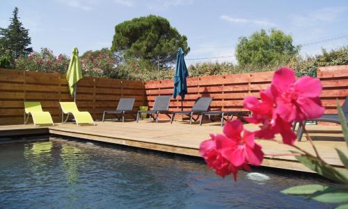 - un groupe de chaises longues et de parasols à côté de la piscine dans l'établissement La Bastide de l'Olivier, au Muy