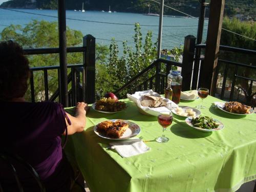 a person sitting at a table with plates of food at Pansion Limni in Keri