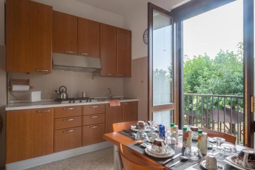 una cocina con armarios de madera y una gran ventana en B&B Le Camelie, en Bareggio