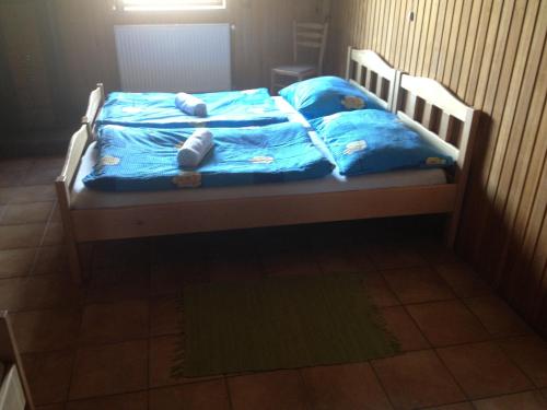 a bed with blue sheets and stuffed animals on it at Penzion Samota in Louka