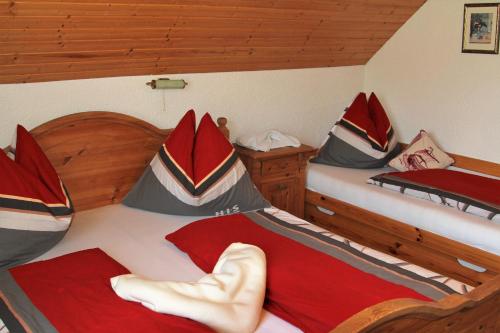a bedroom with two beds with red and gray pillows at Appartements della Schiava in Bad Kleinkirchheim