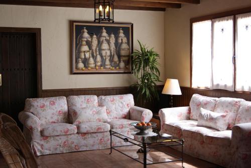 a living room with two couches and a table at Hotel Rural La Paloma in Villanueva de Tapia