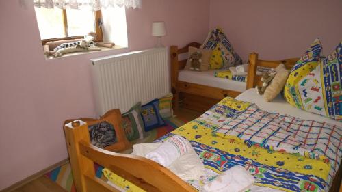a childs bedroom with two beds and a window at Chalupa u studny in Lukov