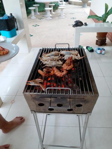una parrilla con carne encima en una habitación en Baan Chockchai 3, en Bang Sare