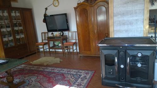 a living room with a stove and a tv at Chalupa u studny in Lukov