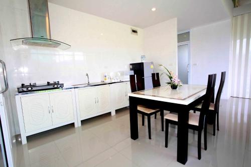 a kitchen with a table and chairs and a sink at Saree Lagoon Villa Koh Samui in Lipa Noi