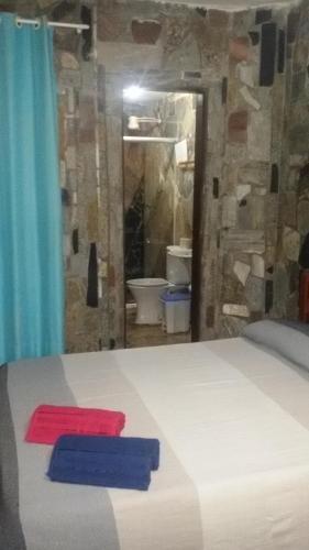 a bedroom with a bed with a red and blue object on it at Casa Italiana 100m mar in Salvador