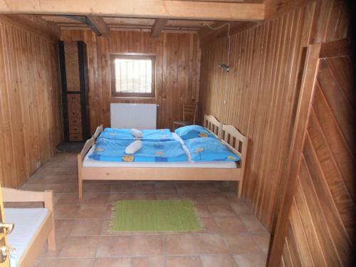 a bedroom with a bed in a wooden room at Penzion Samota in Louka