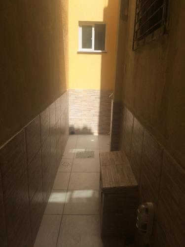 a small hallway with a bench and a window at Green Flat Fortaleza in Fortaleza